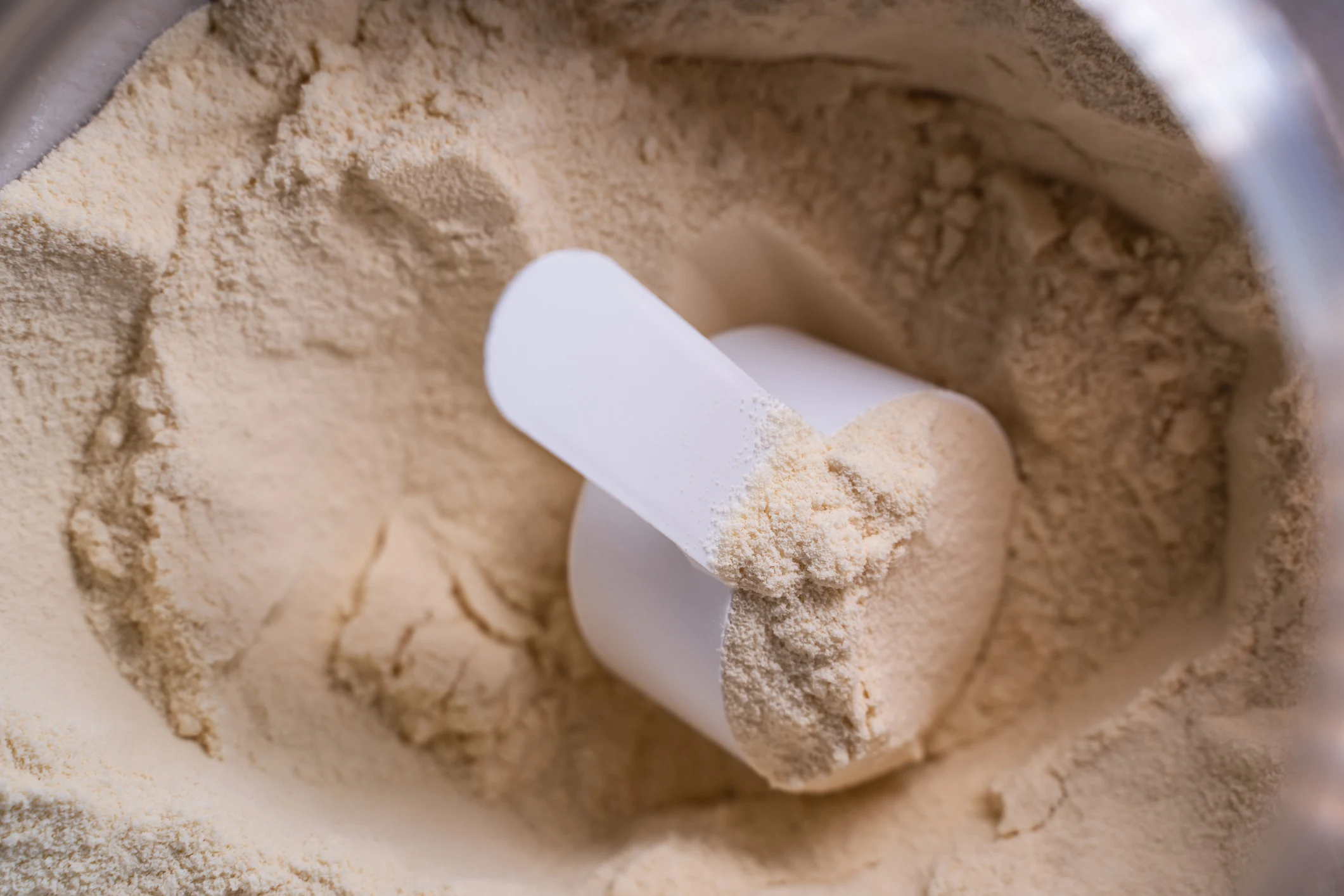 Protein powder and scoop representing Thorne protein and muscle products